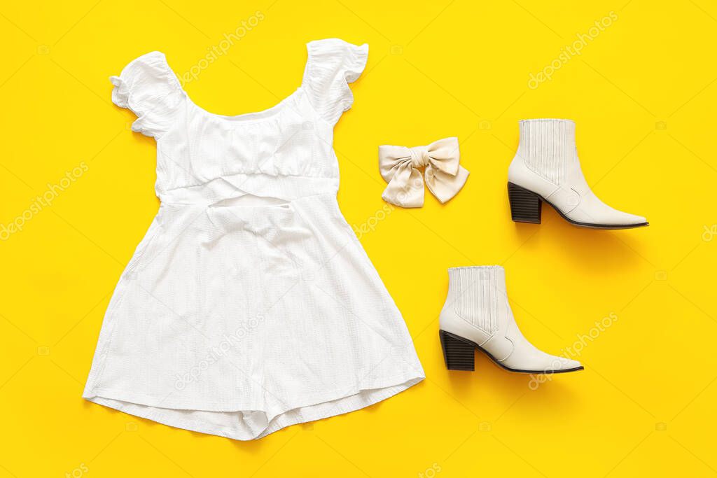 Stylish summer overall jumpsuit, shoes and hair bow on color background