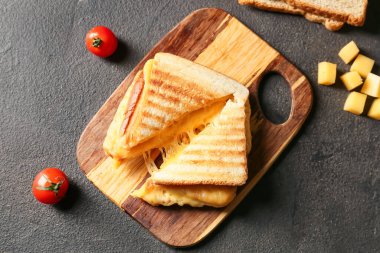 Koyu arkaplanda lezzetli sandviçler olan tahta