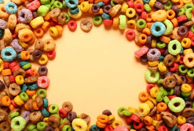 Renkli arkaplanda lezzetli mısır gevreği halkalarından yapılmış çerçeve, yakın plan