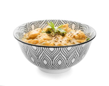 Beyaz arka planda bir kase lezzetli körili tavuk.