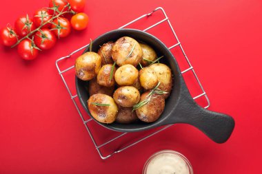 Fırında patatesli tava ve arka planda biberiye.