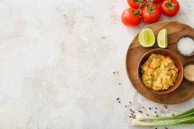 Bir kase lezzetli körili tavuk ve hafif arka planda malzemeler.