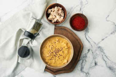 Bir kase lezzetli körili tavuk ve hafif arka planda malzemeler.