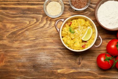 Lezzetli tavuk körisi ve ahşap arka planda malzemeler.