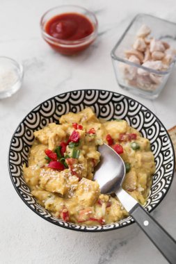 Hafif arka planda bir kase lezzetli körili tavuk.