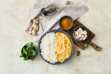 Bir kase lezzetli körili tavuk, pilav ve hafif arka planda malzemeler.