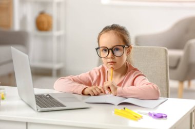 Evde internetten ders alan küçük bir kız.