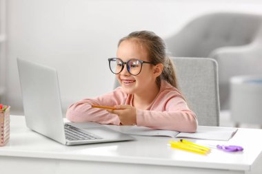 Evde internetten ders alan küçük bir kız.