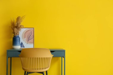 Renk duvarına yakın vazosu olan modern işyeri