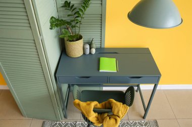 Renk duvarına yakın ev bitkisi olan modern işyeri