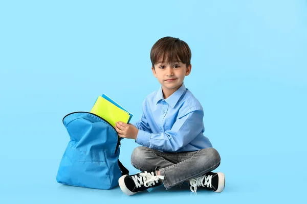 Mały Uczeń Wkładający Zeszyty Plecaka Kolorowe Tło — Zdjęcie stockowe