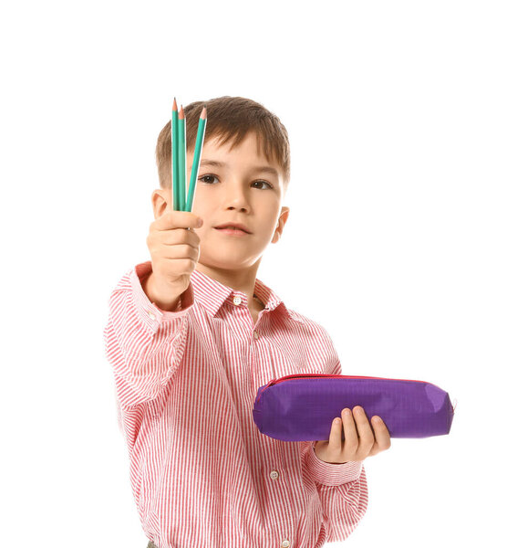 Little boy with pencils and case on white background
