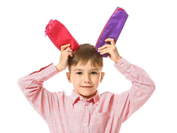 Little boy with pencil cases on white background