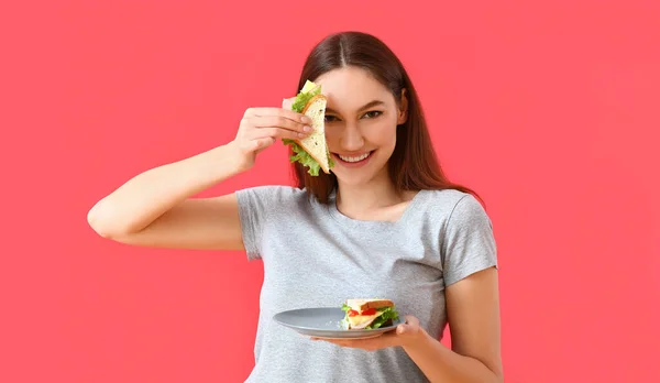 Junge Frau Mit Leckerem Sandwich Auf Farbigem Hintergrund — Stockfoto