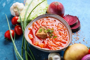 Bir kase lezzetli borş çorbası ve arkaplandaki malzemeler