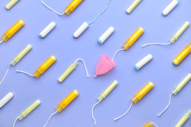 Tamponlar ve regl fincanı renk arkaplanında
