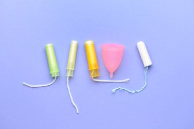 Tamponlar ve regl fincanı renk arkaplanında