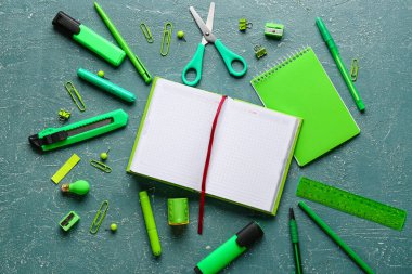 Renk arkaplanı üzerine boş defter ve kırtasiye malzemeleri