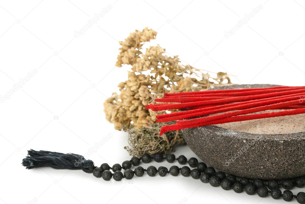 Composition with incense sticks, herbs and Tibetan beads on white background