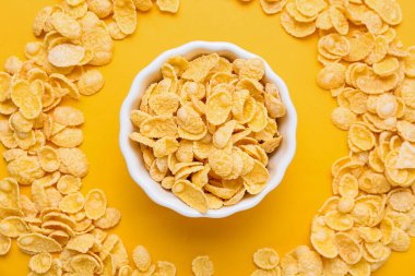 Renkli arkaplanda bir kase lezzetli mısır gevreği ile kompozisyon