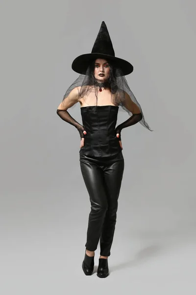 Piękna Kobieta Ubrana Jak Wiedźma Halloween Szarym Tle — Zdjęcie stockowe