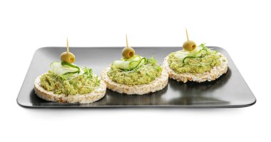 Beyaz arka planda guacamole, zeytin ve salatalıklı pirinç krakerleri