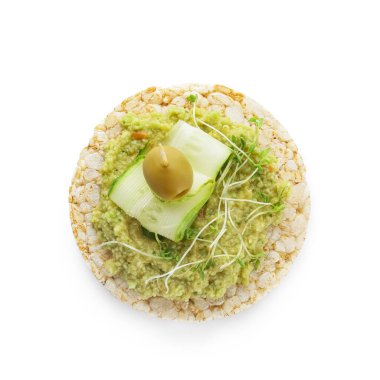 Beyaz arka planda guacamole, zeytin ve salatalıklı pirinç krakeri.