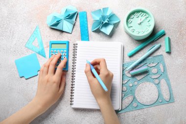 Grunge arka planında defter ve kırtasiye malzemesi olan kadın