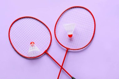 Badminton raketleri ve renkli arka planda mekik horozları