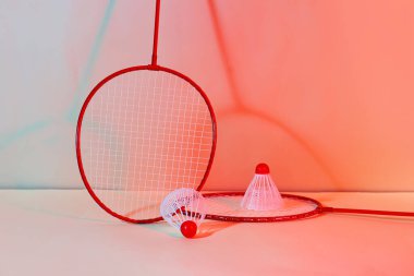 Badminton raketleri ve renkli arka planda mekik horozları