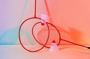 Badminton raketleri ve renkli arka planda mekik horozları