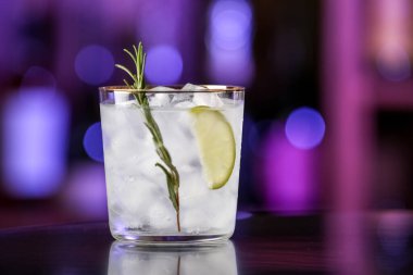 Bardaki masada bir bardak soğuk cin toniği.
