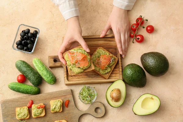 Woman Holding Tasty Sandwich Guacamole Salmon Table — Stock Photo, Image