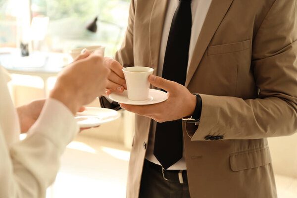 Деловые люди делают перерыв на кофе в офисе