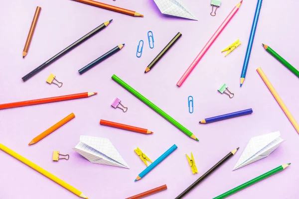 Papierflugzeuge Mit Bleistiften Und Clips Auf Farbigem Hintergrund — Stockfoto