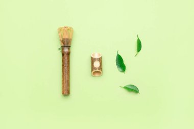 Renkli arkaplanda bambu şasen ve yeşil yapraklı kompozisyon