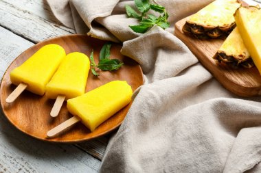 Hafif ahşap arka planda lezzetli ananaslı dondurma tabağı.