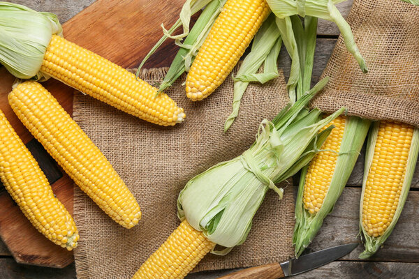 Fresh corn cobs on wooden background