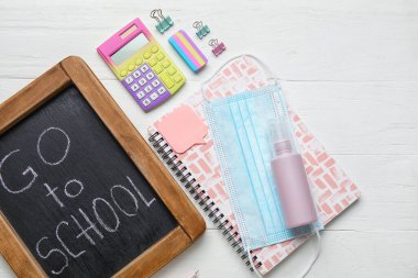 Tahtada beyaz ahşap arka planda GO To OCHOL, kırtasiye ve tıbbi maske