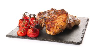 Lezzetli domuz bifteği ve beyaz arka planda ızgara domates.