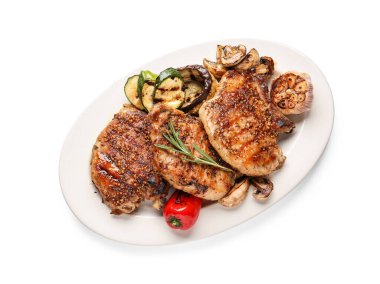 Lezzetli domuz bifteği ve beyaz arka planda ızgara sebze tabağı.