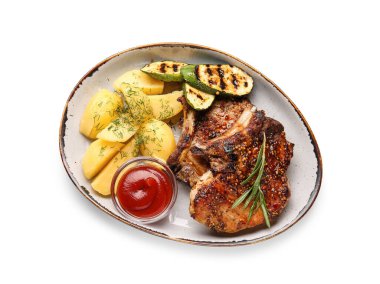 Lezzetli domuz bifteği, domates sosu ve beyaz arka planda ızgara sebze tabağı.