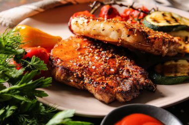 Lezzetli domuz bifteği ve ızgara sebze tabağı, yakın plan.