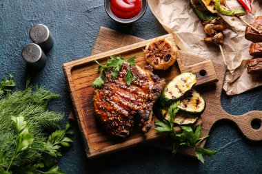 Lezzetli domuz bifteği ve ızgara sebzeli ahşap tahta.