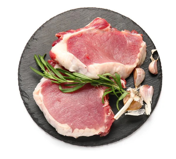 Beyaz arka planda çiğ domuz bifteği ve biberiye.