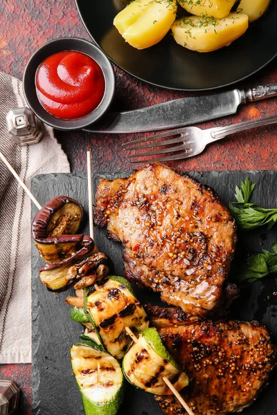 Planche Avec Savoureux Steaks Porc Légumes Grillés Sur Fond Grunge — Photo