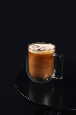 Koyu arkaplanda cam bardak kahve tepsisi.