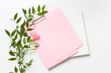 Beyaz arkaplanda boş kağıt, poster, çiçek ve bitki dalı olan pano