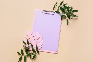 Renk arkaplan üzerinde pano, boş kağıt ve yeşil yapraklar bileşimi