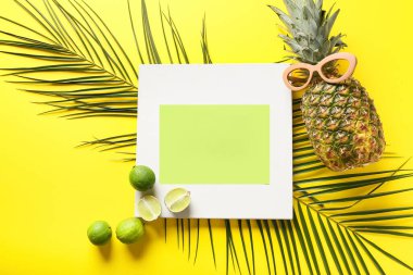 Renk arkaplanında boş kart, meyve, güneş gözlüğü ve palmiye yaprakları içeren kompozisyon